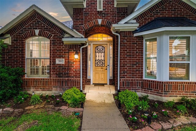 entrance to property featuring brick siding