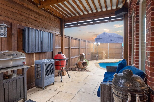 patio terrace at dusk featuring a fenced backyard