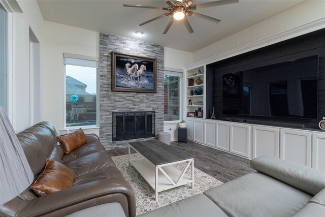 living area with ceiling fan, wood finished floors, and a large fireplace