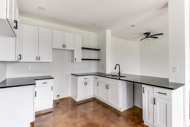 kitchen with a sink, dark countertops, a ceiling fan, and concrete flooring