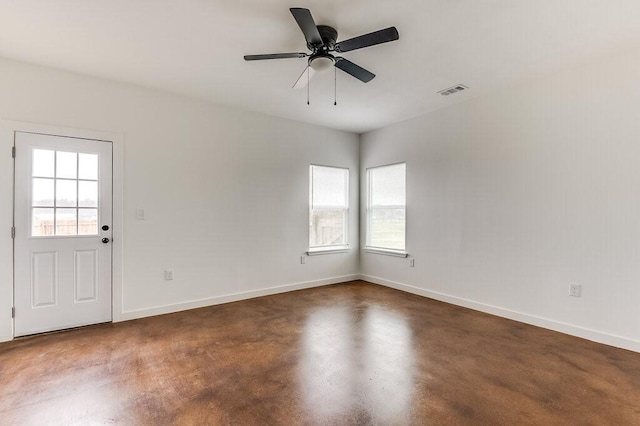 spare room featuring baseboards, ceiling fan, and visible vents
