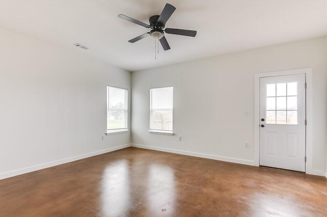 spare room with a healthy amount of sunlight, baseboards, ceiling fan, and visible vents