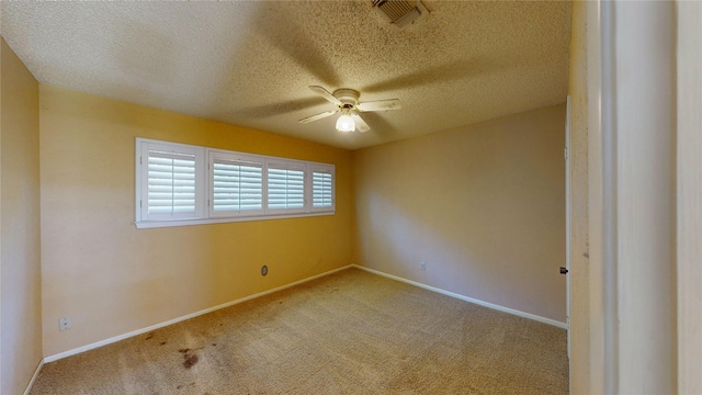 unfurnished room featuring a ceiling fan, carpet flooring, a textured ceiling, and visible vents