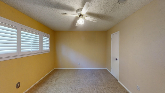 spare room featuring carpet floors, a textured ceiling, ceiling fan, and baseboards