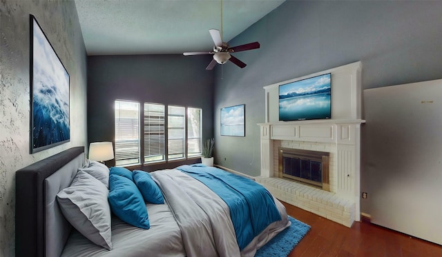 bedroom with wood finished floors, a fireplace, baseboards, ceiling fan, and high vaulted ceiling