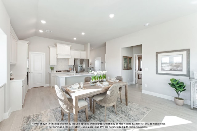 dining space with recessed lighting, light wood-style floors, visible vents, and vaulted ceiling