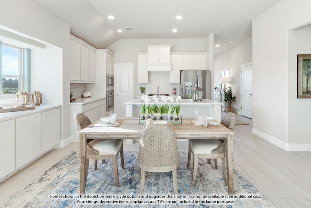 dining space with recessed lighting, baseboards, lofted ceiling, light wood-type flooring, and visible vents