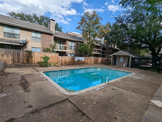 pool with a fenced backyard and a patio area