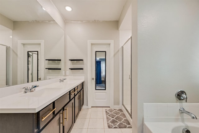 full bath featuring a tub to relax in, a sink, tile patterned flooring, and a stall shower