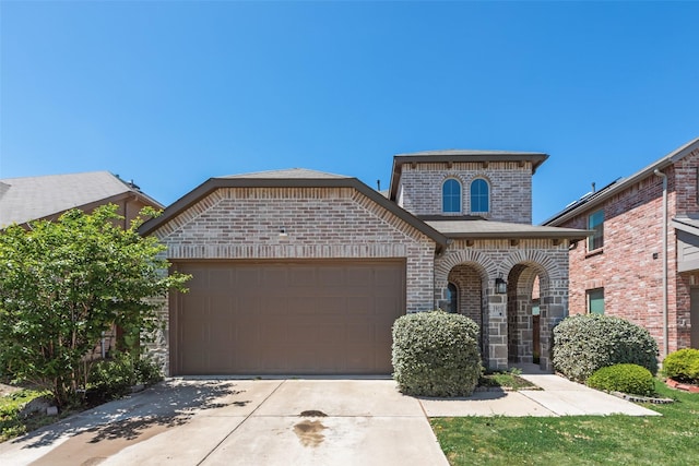 view of front of property with an attached garage, driveway, and brick siding