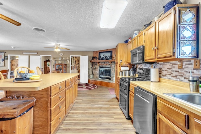 kitchen featuring a textured ceiling, visible vents, light wood-type flooring, light countertops, and stainless steel appliances