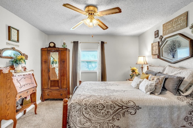 carpeted bedroom featuring a textured ceiling and ceiling fan