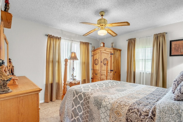bedroom with baseboards, a textured ceiling, light carpet, and ceiling fan