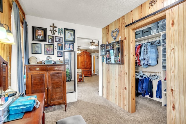interior space with carpet flooring, a textured ceiling, and wood walls