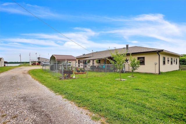 back of house featuring a yard, fence, a detached carport, and dirt driveway