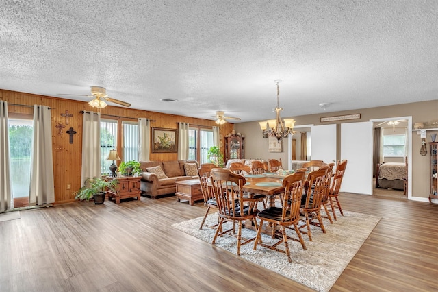 dining room featuring ceiling fan with notable chandelier and a textured ceiling