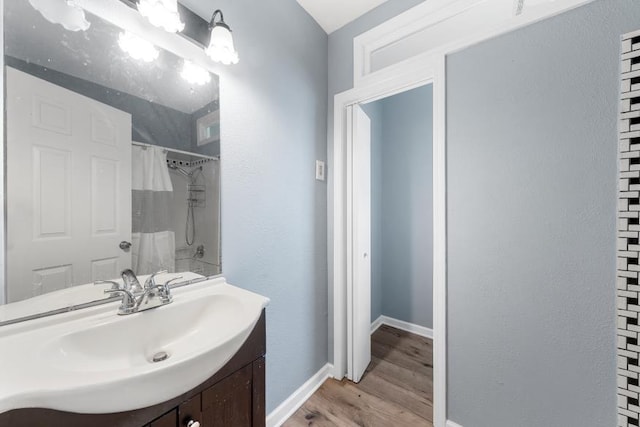 full bathroom with vanity, baseboards, wood finished floors, and curtained shower