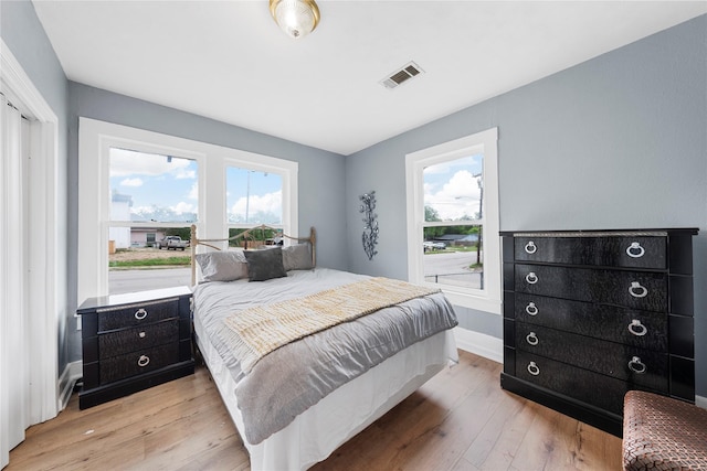 bedroom featuring baseboards, visible vents, and light wood-style flooring