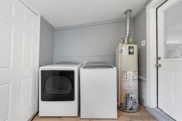 washroom with light wood-style floors, gas water heater, laundry area, and washing machine and clothes dryer