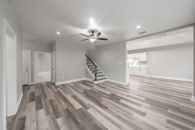 unfurnished living room featuring visible vents, recessed lighting, stairs, and light wood-style flooring