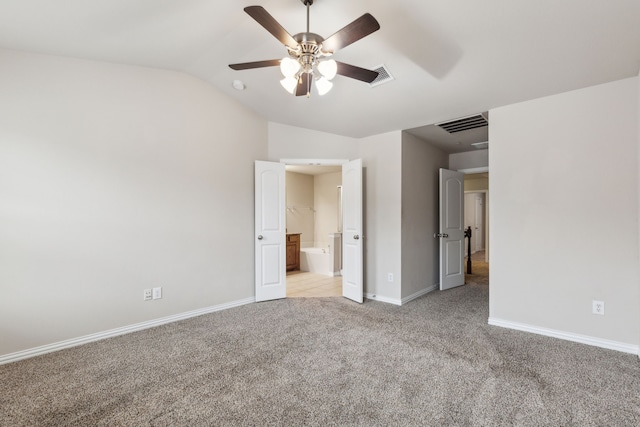unfurnished bedroom featuring baseboards, visible vents, light carpet, and vaulted ceiling