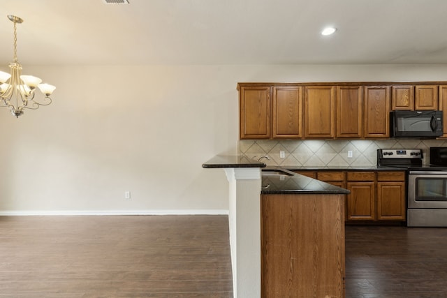 kitchen featuring brown cabinets, a chandelier, black microwave, and stainless steel range with electric stovetop