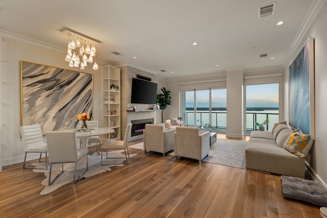 2800 Lakeside Pkwy Unit 1003, Flower Mound, TX 75022 - living area with visible vents, a large fireplace, wood finished floors, ornamental molding, and recessed lighting