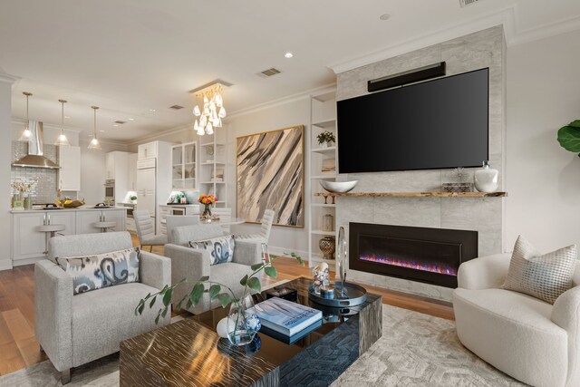 2800 Lakeside Pkwy Unit 1003, Flower Mound, TX 75022 - living area featuring visible vents, ornamental molding, a fireplace, light wood-type flooring, and built in shelves