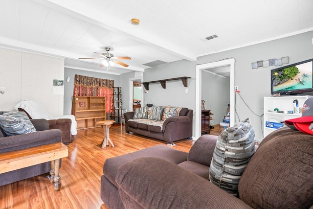 living room with a ceiling fan, beam ceiling, visible vents, and wood finished floors