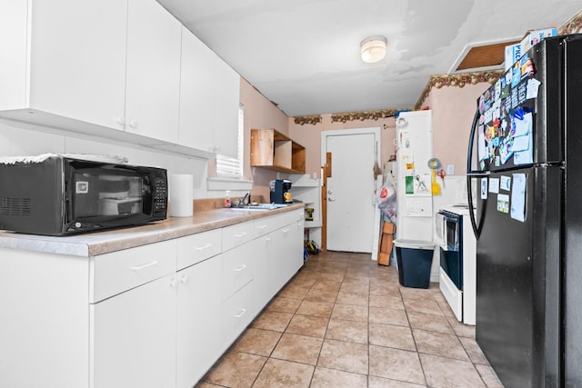 kitchen with a sink, light countertops, white cabinets, and black appliances