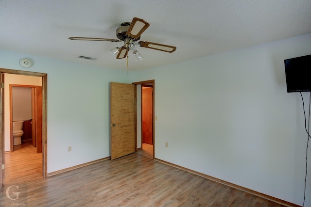 unfurnished bedroom with baseboards, a ceiling fan, light wood finished floors, and visible vents