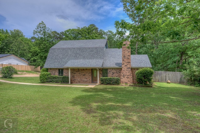 view of front facade featuring fence, a shingled roof, and a front yard