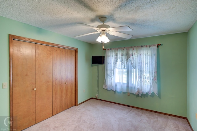 unfurnished bedroom with a ceiling fan, baseboards, light carpet, and a closet