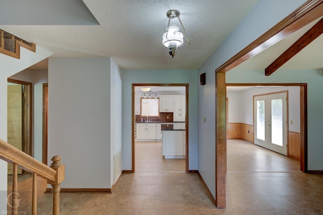 hall featuring stairs, a textured ceiling, visible vents, and a sink
