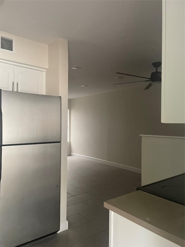 7030 Fair Oaks Ave Unit 111, Dallas, TX 75231 - kitchen featuring a ceiling fan, visible vents, baseboards, freestanding refrigerator, and white cabinetry