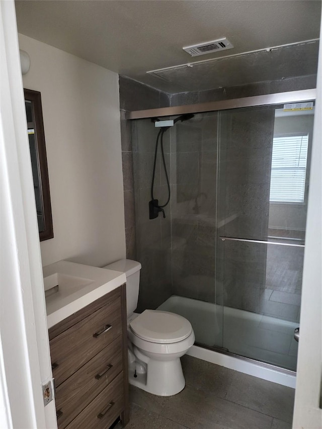7030 Fair Oaks Ave Unit 111, Dallas, TX 75231 - full bathroom with vanity, visible vents, wood finished floors, toilet, and a shower stall