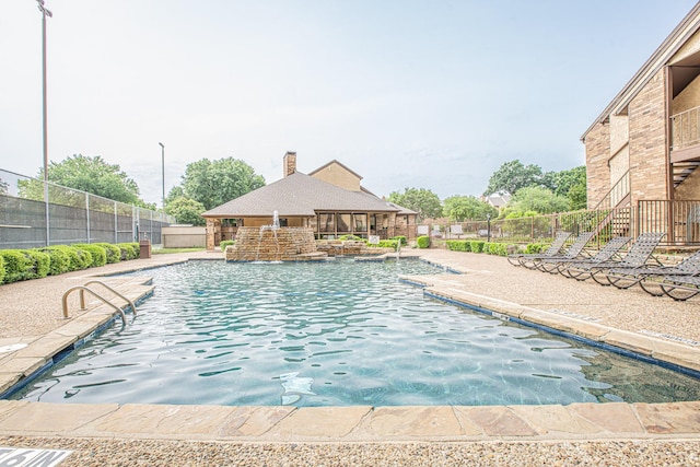 pool featuring fence and a patio area
