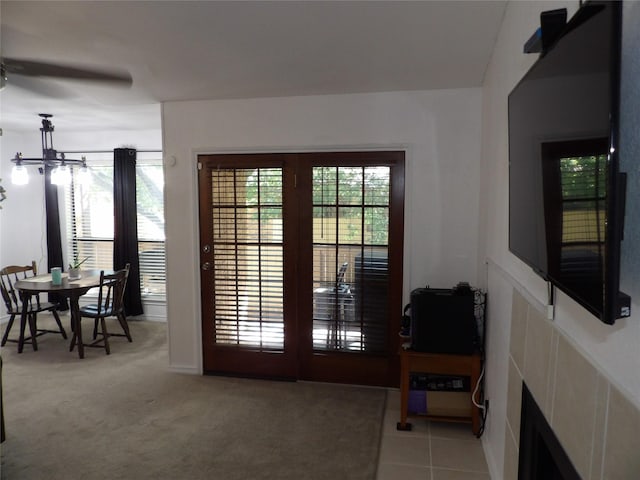 doorway with light carpet and ceiling fan with notable chandelier