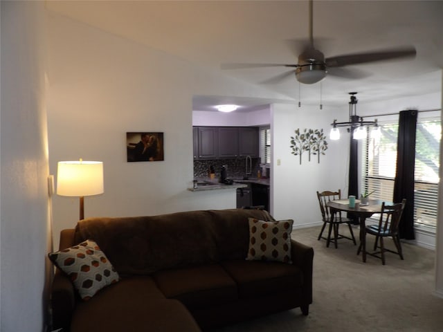 living room with ceiling fan, light colored carpet, and baseboards