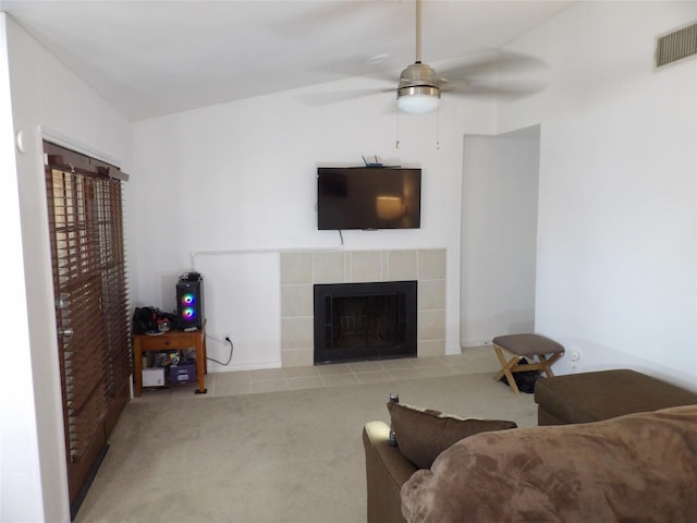 carpeted living room featuring a ceiling fan, visible vents, and a tile fireplace