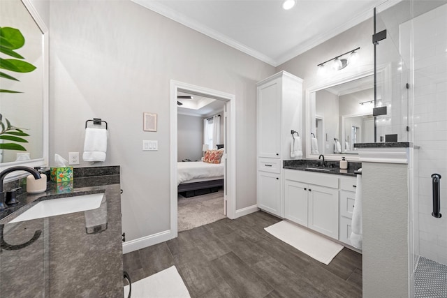 bathroom featuring a sink, wood finished floors, two vanities, and ornamental molding