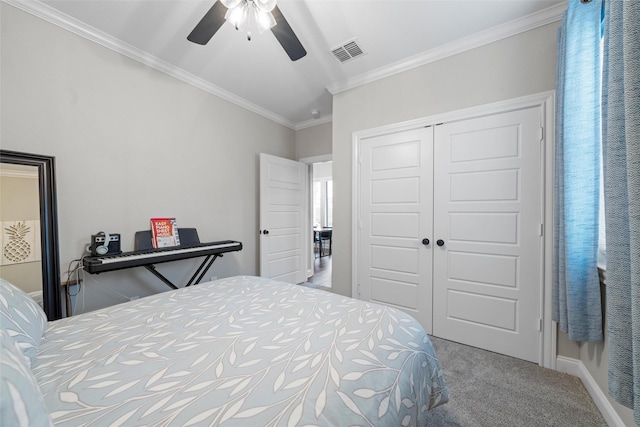 bedroom featuring a ceiling fan, visible vents, carpet floors, a closet, and ornamental molding