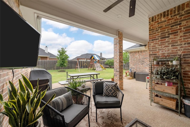 view of patio featuring ceiling fan, an outdoor living space, a fenced backyard, and a playground