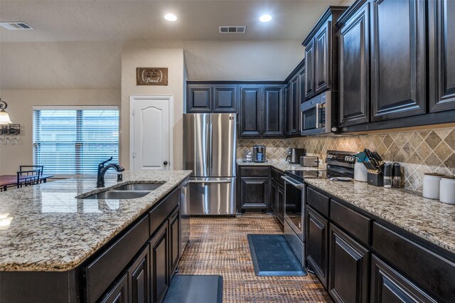 kitchen featuring a sink, decorative backsplash, stainless steel appliances, and visible vents