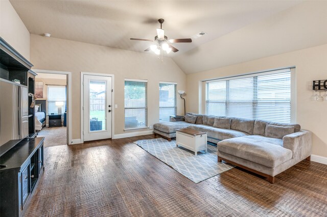living room featuring visible vents, lofted ceiling, wood finished floors, baseboards, and a ceiling fan