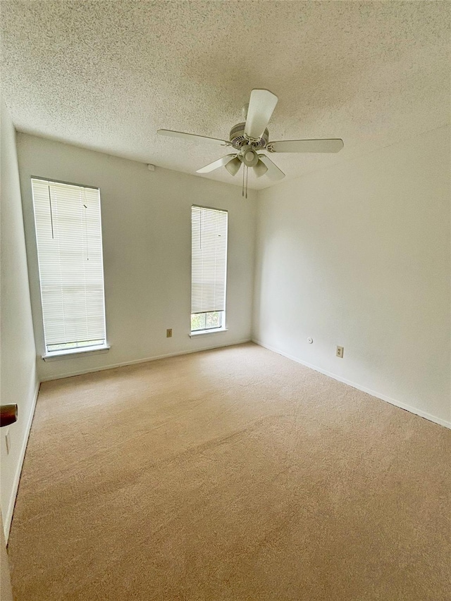 spare room featuring baseboards, carpet, and a textured ceiling