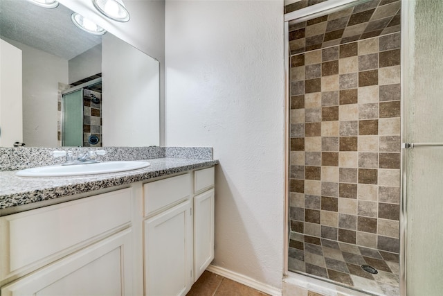 bathroom with vanity, tile patterned flooring, and a shower stall