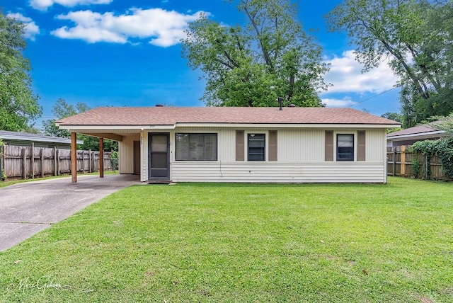 ranch-style house featuring fence, a carport, concrete driveway, and a front yard