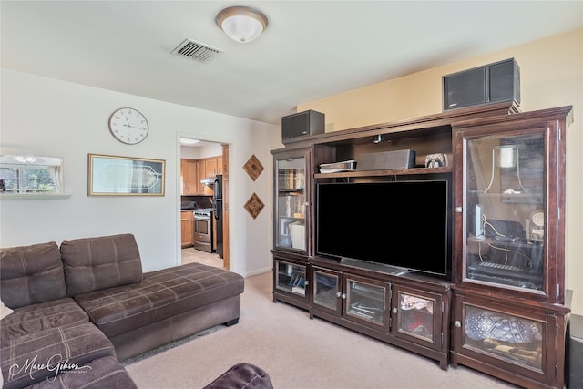living area featuring visible vents and light carpet