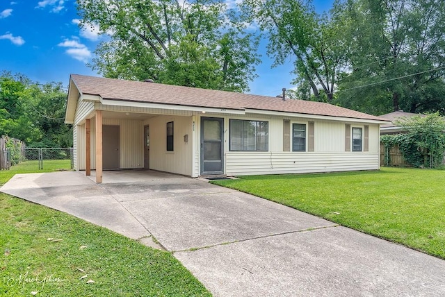 ranch-style house with a front lawn, fence, an attached carport, a shingled roof, and driveway